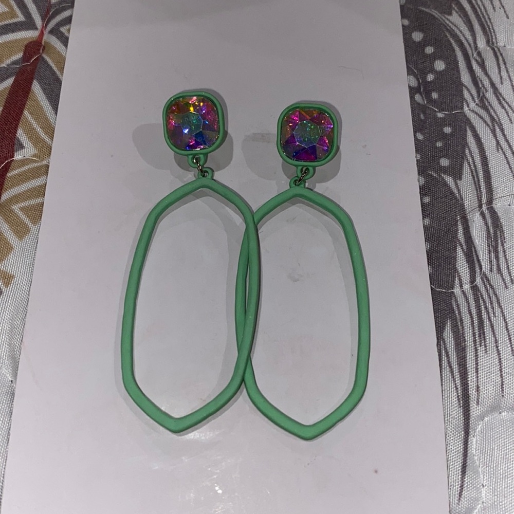 Earrings dangle mint green with iridescent stones.